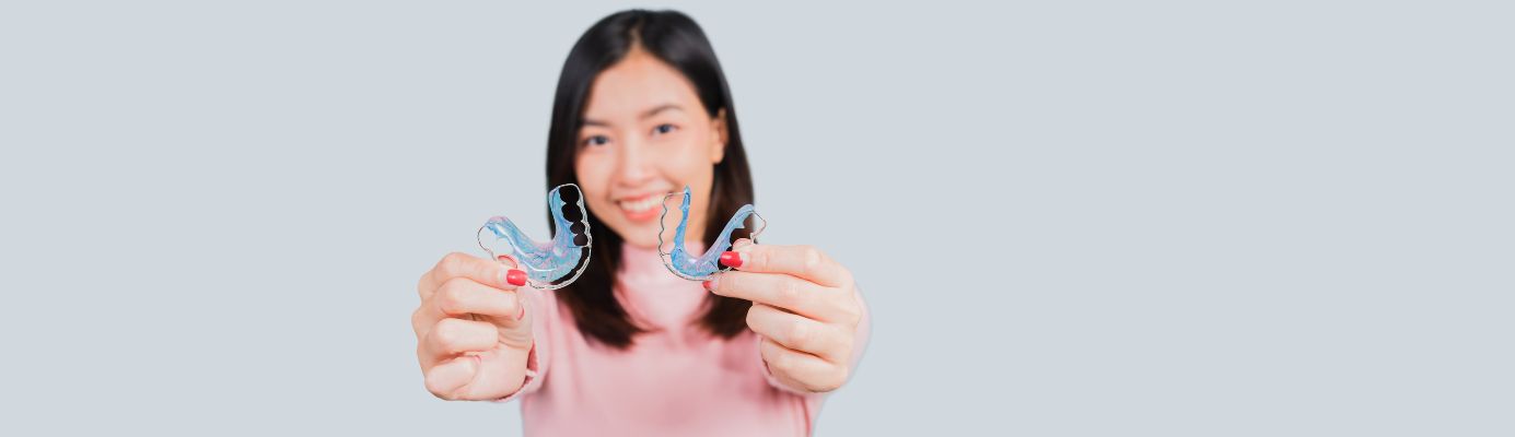 Young woman holding two retainers