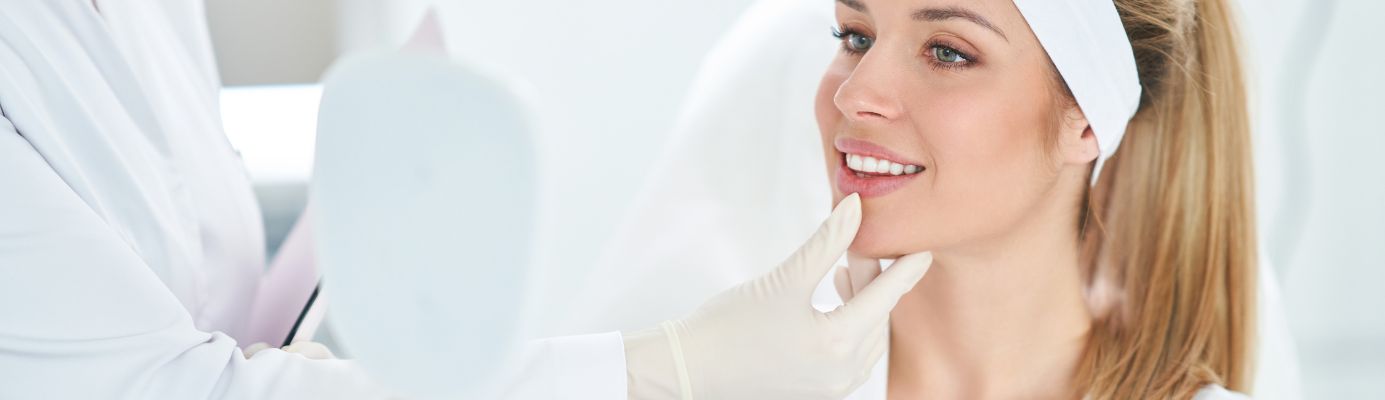 A woman examining herself in a mirror after a Botox treatment